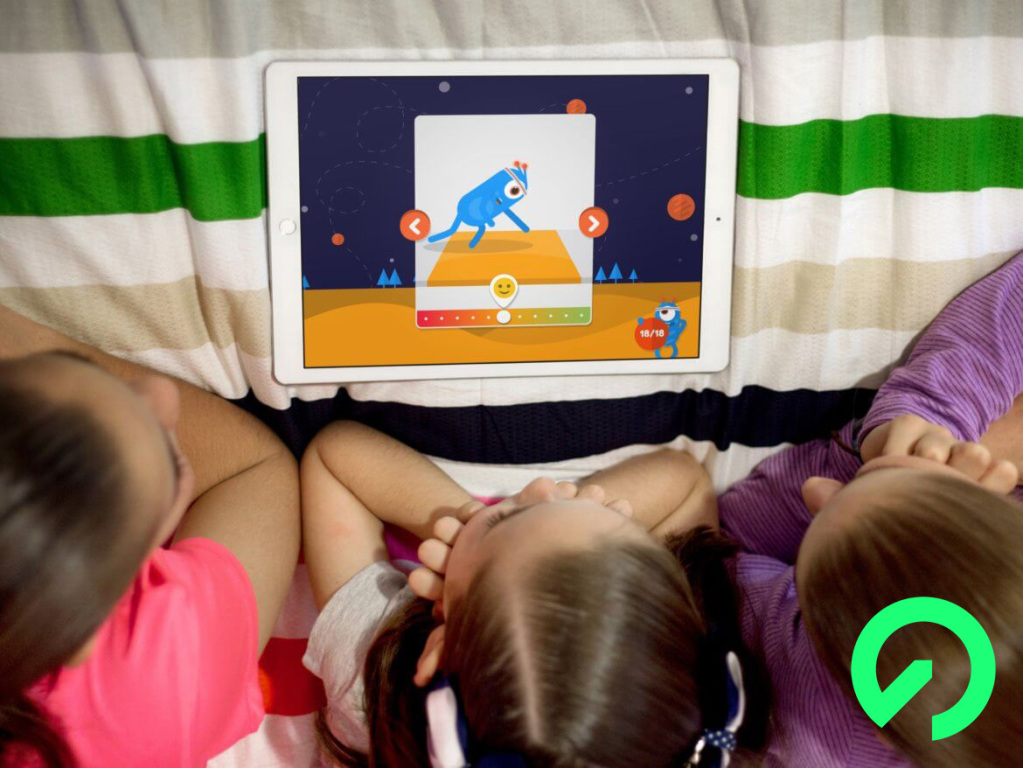 3 children resting on their elbows and looking at an iPad that shows the I LIKE application